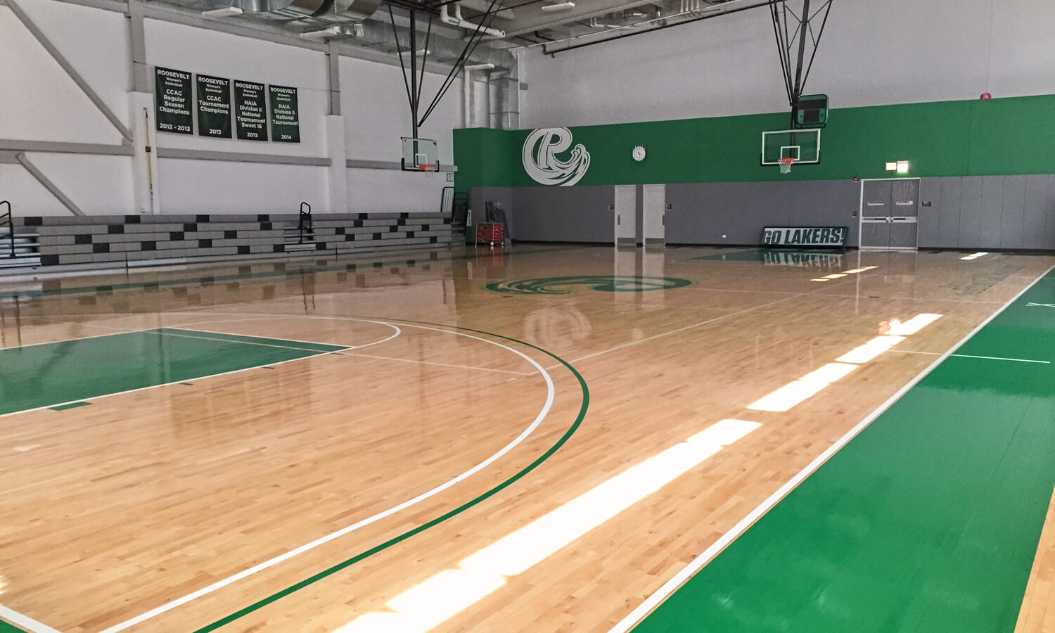 A view of the Goodman Center basketball court with green Roosevelt colors featured on the walls and floor.