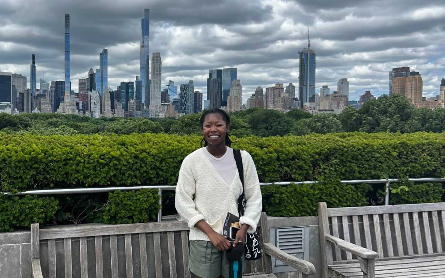 Roosevelt student Mia Moore stands with the New York City skyline behind her