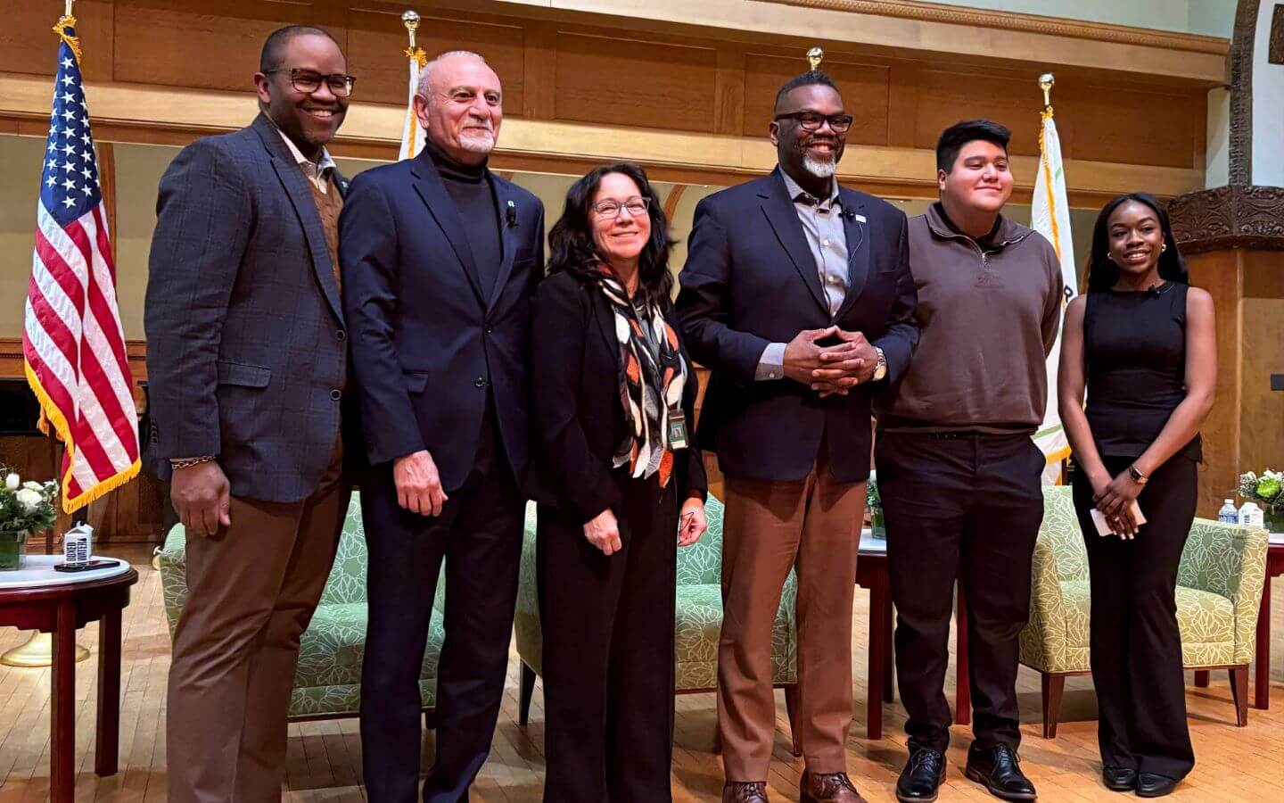 Mayor Brandon Johnson, Ali Malekzadeh, Michael Ford, Heather Dalmage, Treasure Thomas, Leswin Ramirez standing on stage after panel discussion.