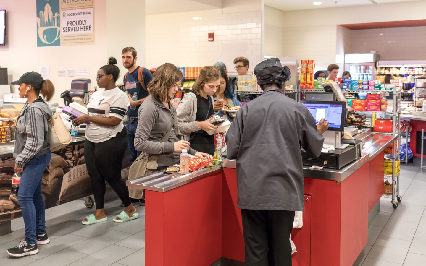 A view of students in dining center check out line purchasing food items.