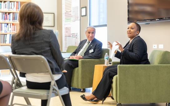 Colleagues sitting in chairs having a professional discussion.